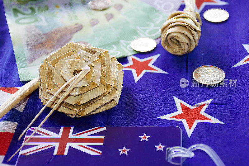 新西兰货币(NZD);美元和硬币与Kiwiana Putiputi花